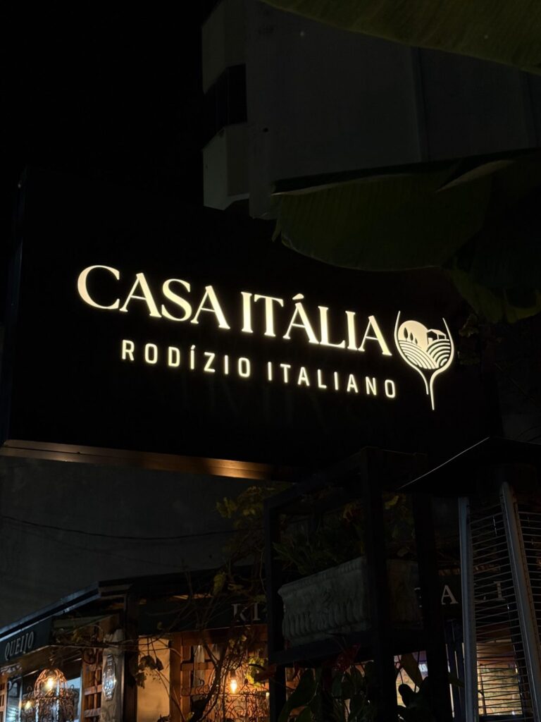 The lit sign of Casa Itália, an Italian restaurant, in the evening