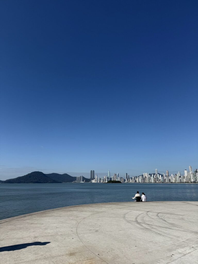 The towers of Centro along the curve of Praia Central, seen from the Pontal Norte end of the bay